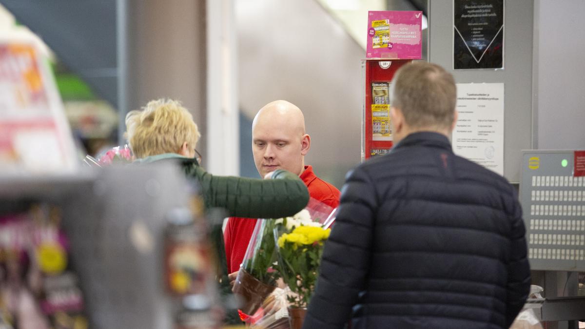 Photo: People queuing to the cashier desk in a shop.