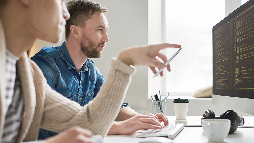 Ihmisiä tietokoneen ääressä