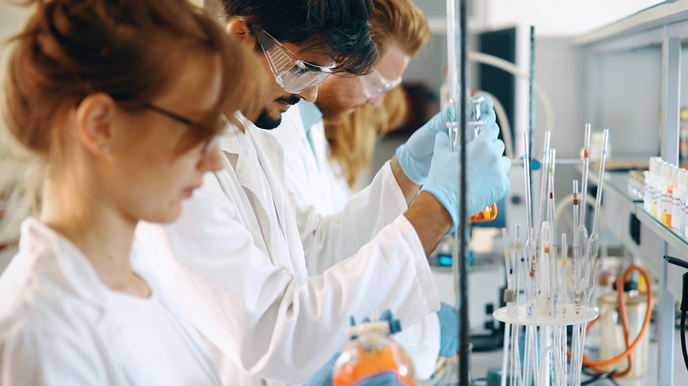 Internationella studerande arbetar vid ett laboratorium.