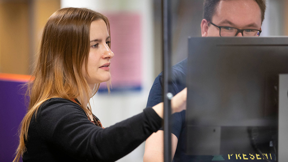 Kuvassa TE-palvelujen asiantuntija opastaa asiakasta tietokoneen äärellä.